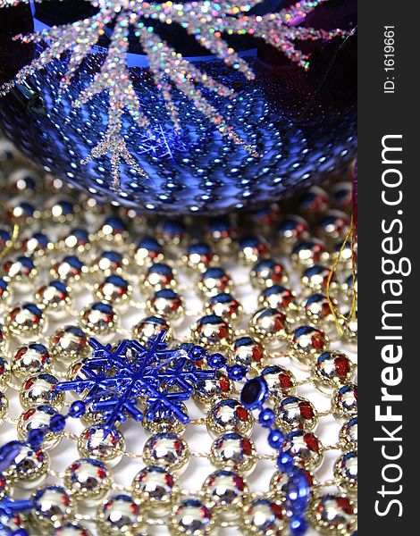 Glass christmas sphere and snowflake of dark blue color on a background made of a beads