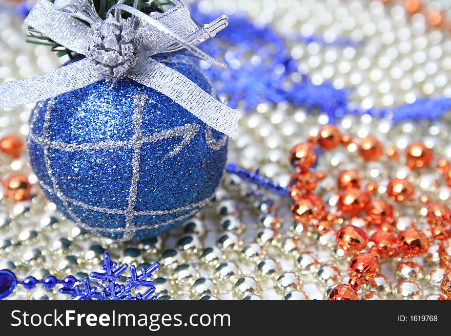 Christmas sphere of dark blue color with a pattern on a background of a multi-coloured beads