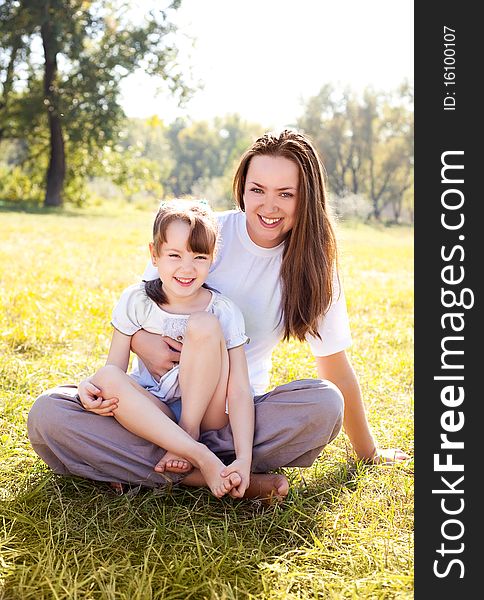 Beautiful young mother and her daughter in the park on a sunny autumn day. Beautiful young mother and her daughter in the park on a sunny autumn day