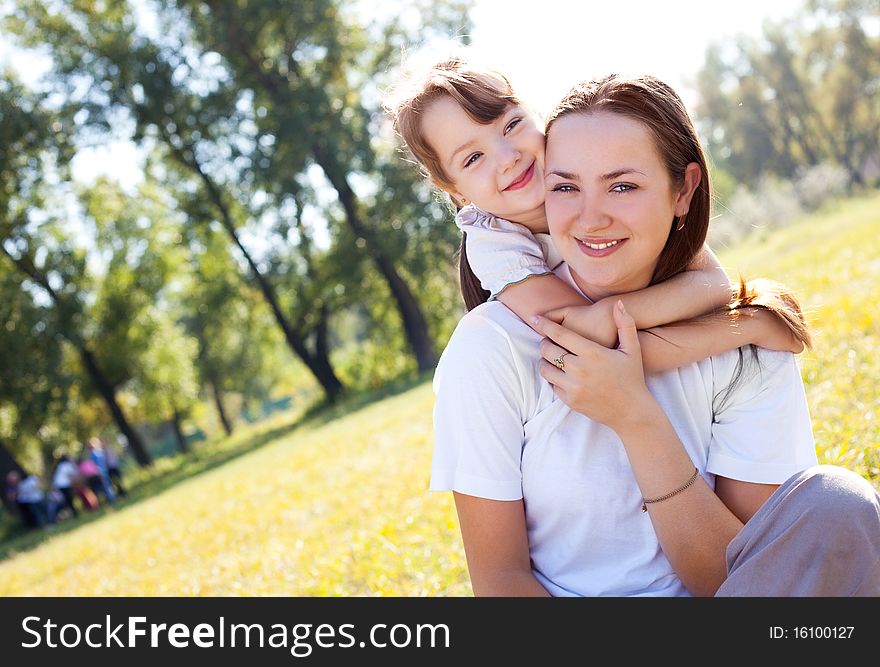 Beautiful young mother and her daughter in the park on a sunny autumn day. Beautiful young mother and her daughter in the park on a sunny autumn day