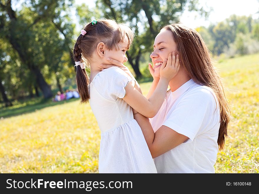 Beautiful young mother and her daughter in the park on a sunny autumn day. Beautiful young mother and her daughter in the park on a sunny autumn day