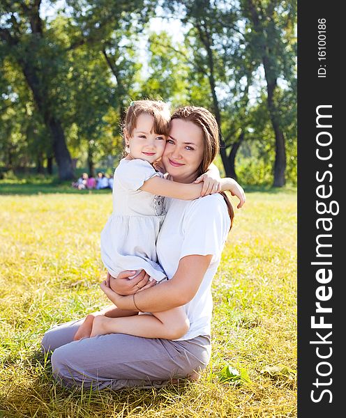 Beautiful young mother and her daughter in the park on a sunny autumn day. Beautiful young mother and her daughter in the park on a sunny autumn day