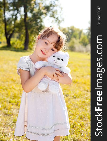 Cute happy little girl with a toy in the autumn park on  a warm sunny day. Cute happy little girl with a toy in the autumn park on  a warm sunny day