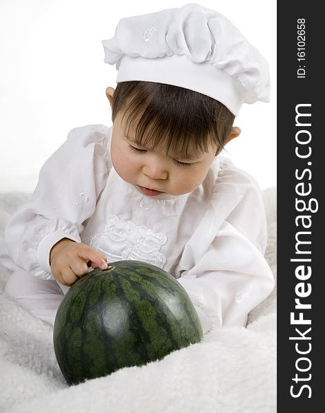 Little girl in the cook costume sitting with watermelon. Little girl in the cook costume sitting with watermelon
