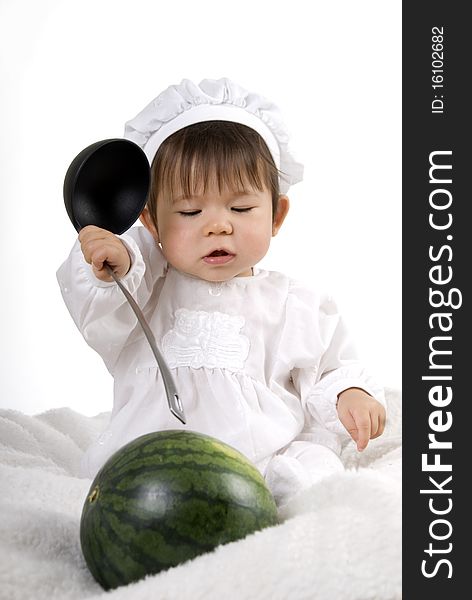Little girl in the cook costume sitting with watermelon with ladle in hand. Little girl in the cook costume sitting with watermelon with ladle in hand