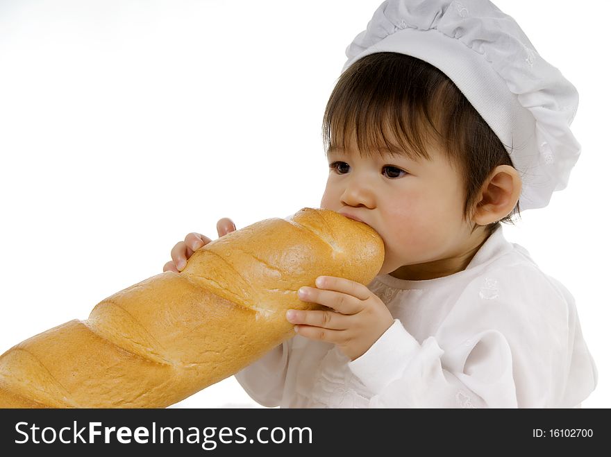 Baby in white cook dress holding bread and eating. Baby in white cook dress holding bread and eating