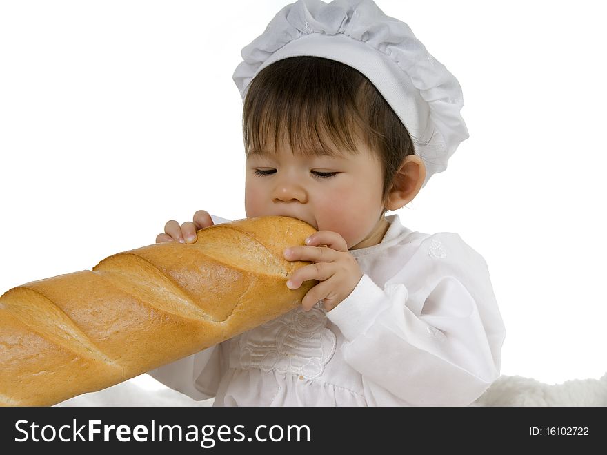 Baby in cook dress eating baguette and holding bread with hand. Baby in cook dress eating baguette and holding bread with hand