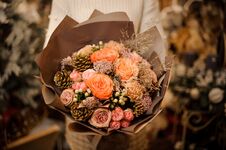 Girl Holding A Bouquet Of Pink And Orange Roses Decorated With Golden Cones Stock Photo