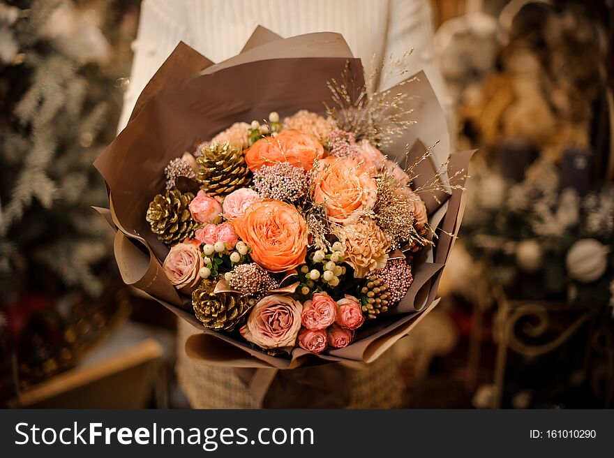 Girl Holding A Bouquet Of Pink And Orange Roses Decorated With Golden Cones