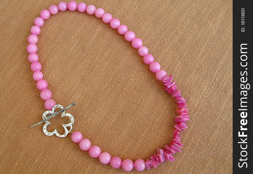 Pink necklace with silver flower-shaped clasp