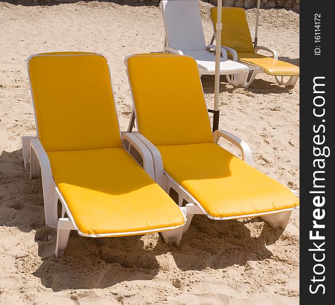 Deckchairs on the beach .