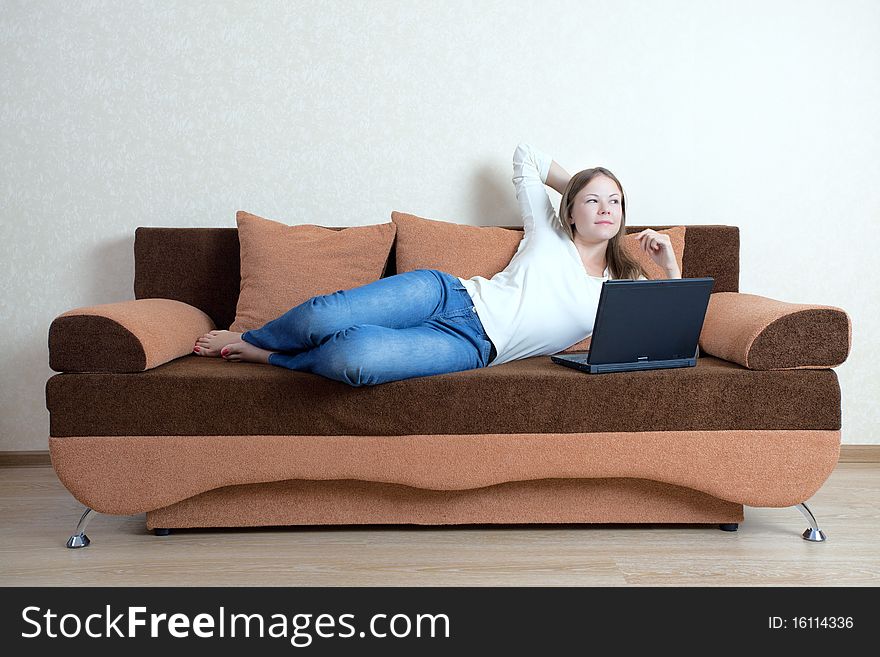 Young beatiful woman with laptop on the sofa