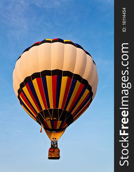 Colorful balloon in blue sky with two rider. Colorful balloon in blue sky with two rider