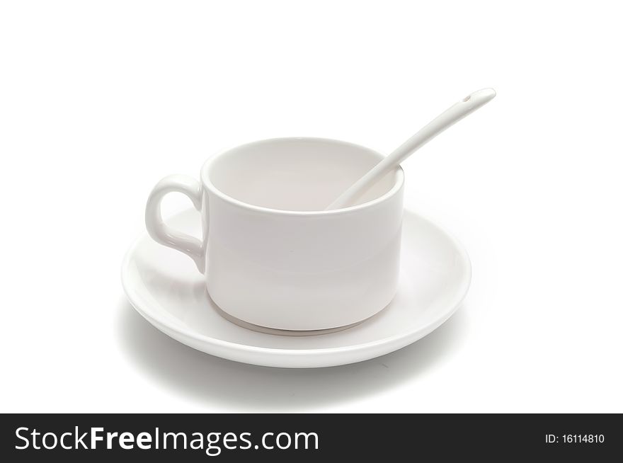 White coffee cup with a spoon on the saucer isolated on white background