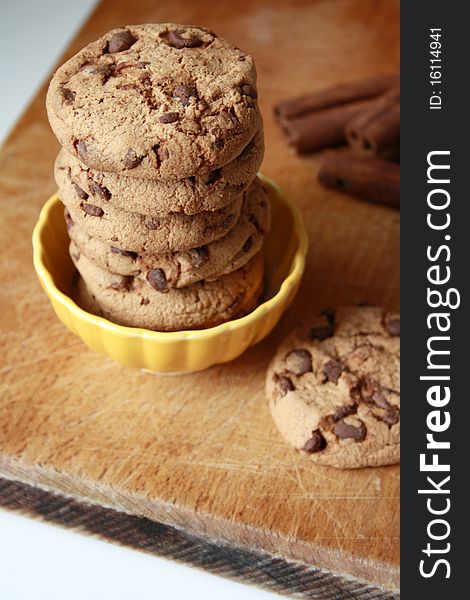 Chocolate chip cookies and cinnamon on a wooden table