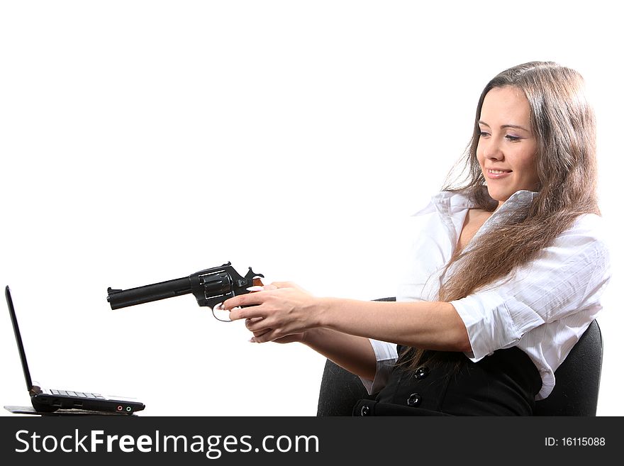 Beatuifull businesswomen is aiming a revolver at a notebook