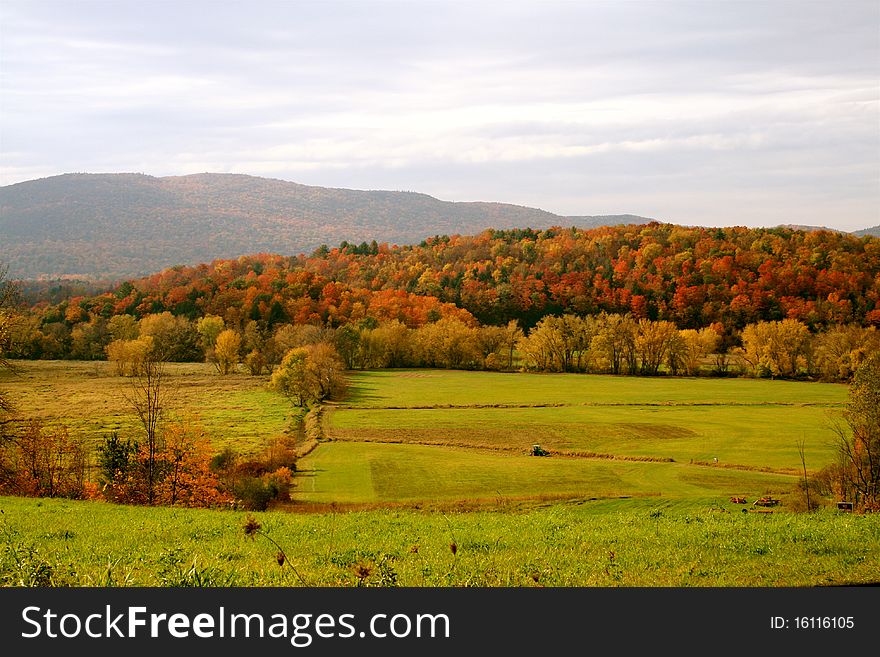 Mountains of colors surround fields on a sunny autumn day in Vermont. Mountains of colors surround fields on a sunny autumn day in Vermont.
