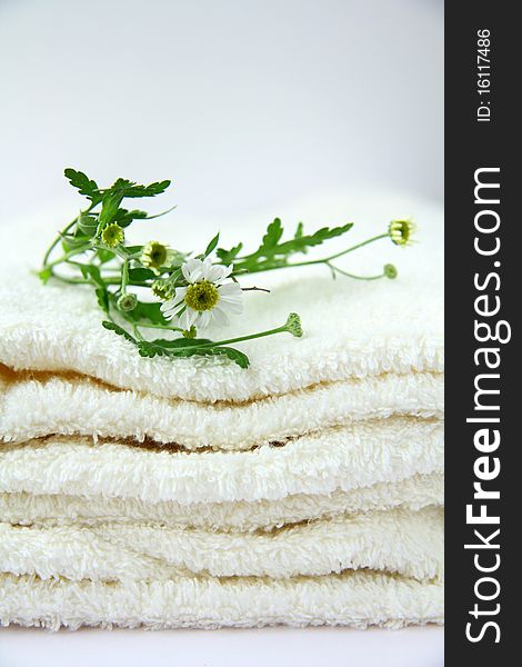 White towel with chamomile flowers on the table