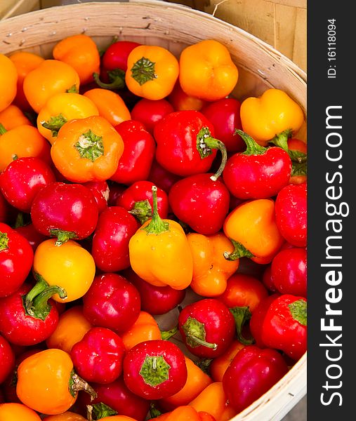 Small yellow, red and orange peppers for sale at a local farmer's market. Small yellow, red and orange peppers for sale at a local farmer's market.