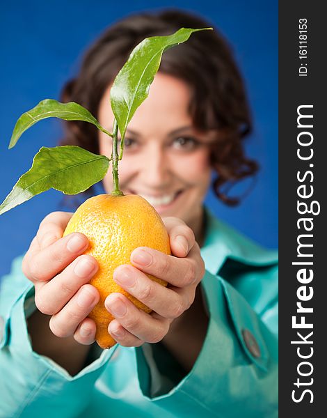 Close-up of smiling female holding fresh lemon with green leaves, focus on hands. Close-up of smiling female holding fresh lemon with green leaves, focus on hands