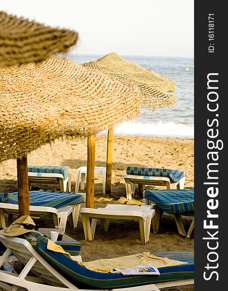 Straw umbrella on the beach and chairs. Straw umbrella on the beach and chairs