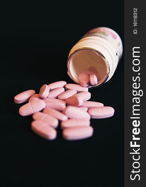 A box with few pills in black backgound