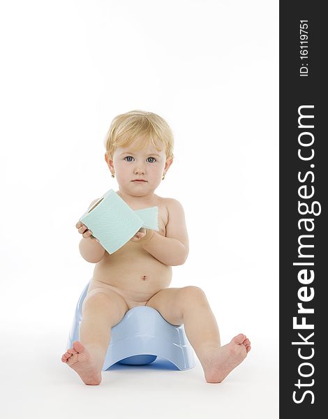 Infant on chamber and toilet paper, on white background.