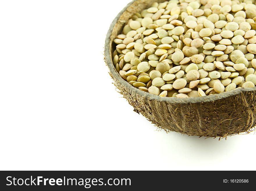 Lentils in a coconut shell bowl isolated on white background