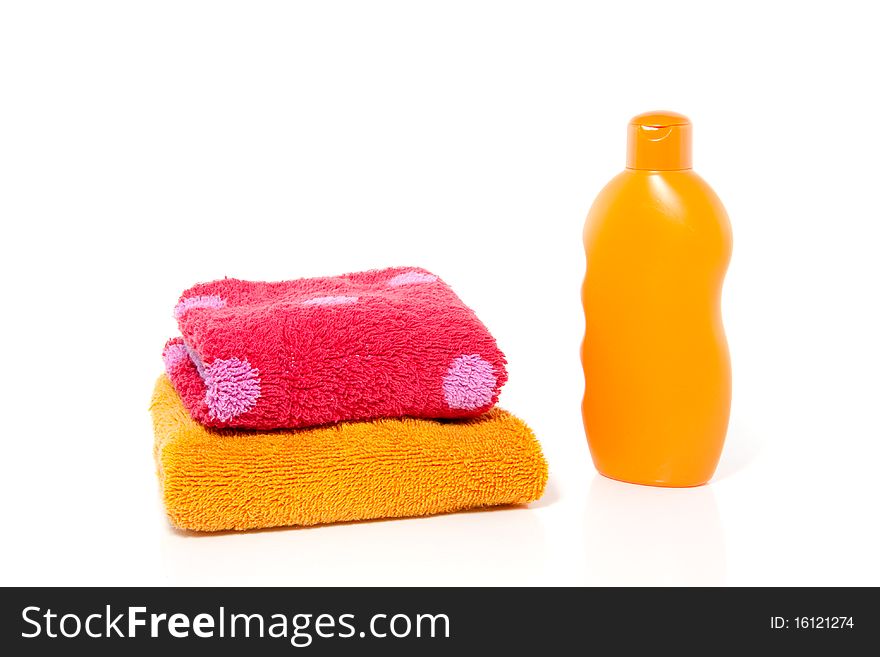 Colorful terry towels and a bottle of showergel isolated over white. Colorful terry towels and a bottle of showergel isolated over white