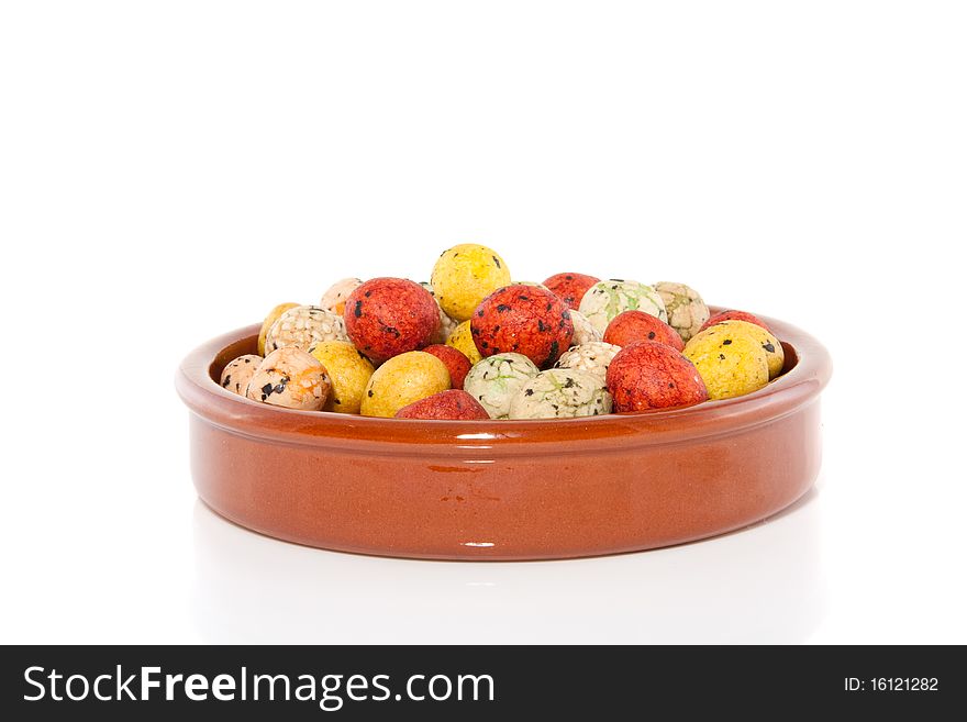 Japanese and sesame snacking crackers in a terracotta brown bowl isolated over white. Japanese and sesame snacking crackers in a terracotta brown bowl isolated over white
