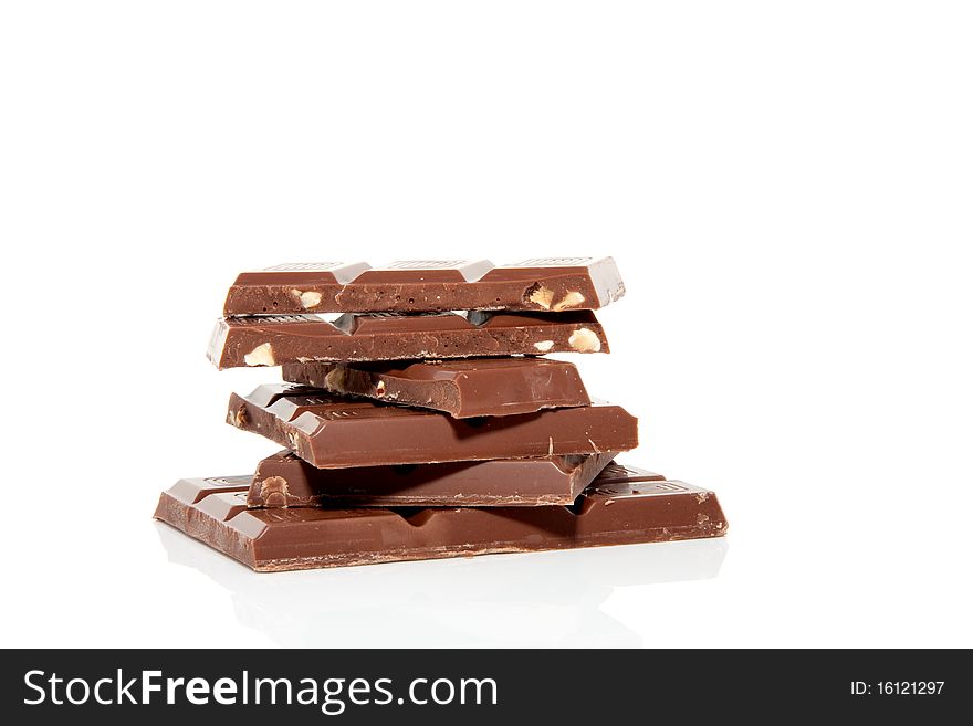 Stack of broken chocolate bars isolated over white