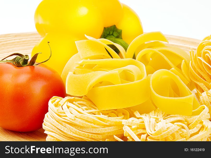 Raw Italian pasta on plate, tomato and pepper