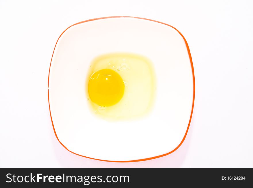 Egg in white bowl and the red rim