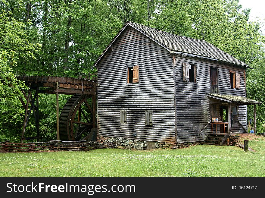 Old rustic gristmill nestled in the back hills of South Carolina surrounded by lush green trees. Old rustic gristmill nestled in the back hills of South Carolina surrounded by lush green trees
