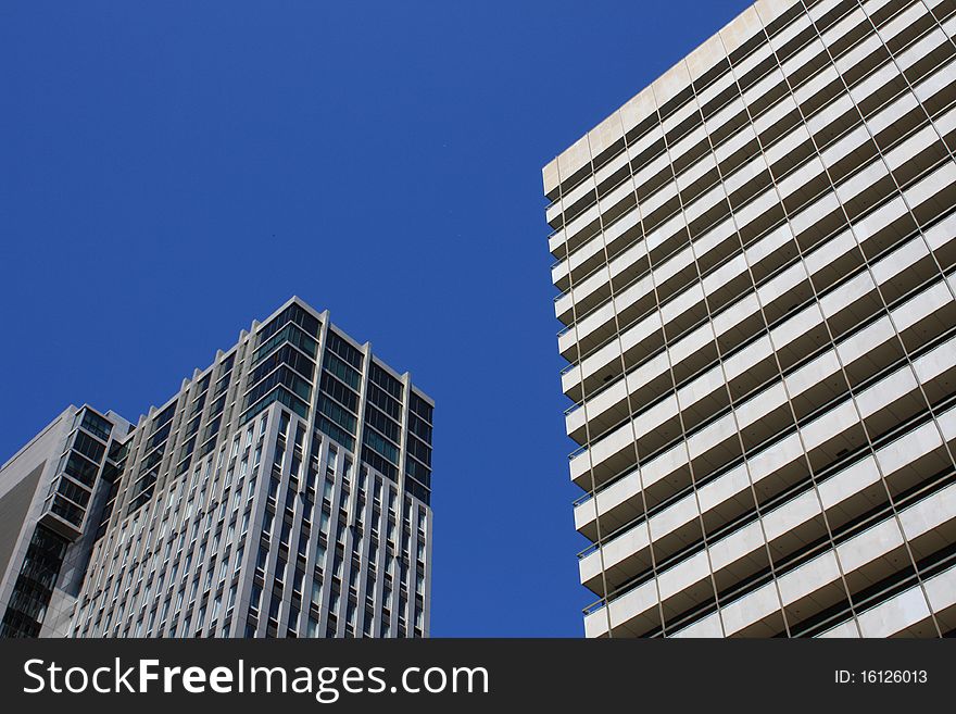 Two modern buildings against a blue sky