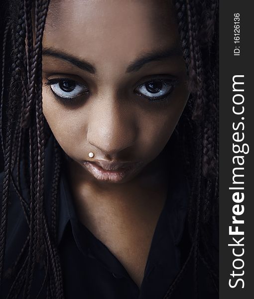 Portrait of a beautiful young black woman posing in black background.