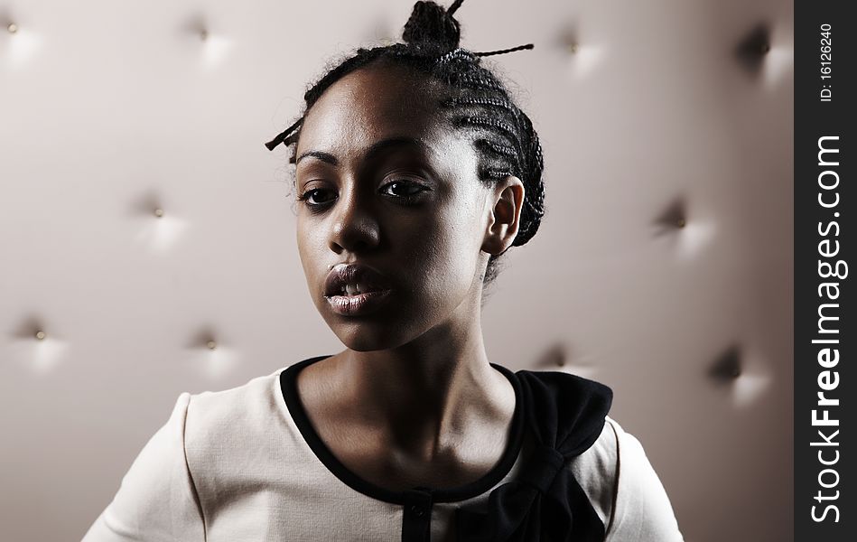 Close-up portrait of Beautiful African woman pose on a beige leather background.