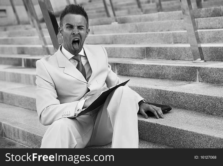 Handsome business man on the stairs reviewing his notes. Handsome business man on the stairs reviewing his notes