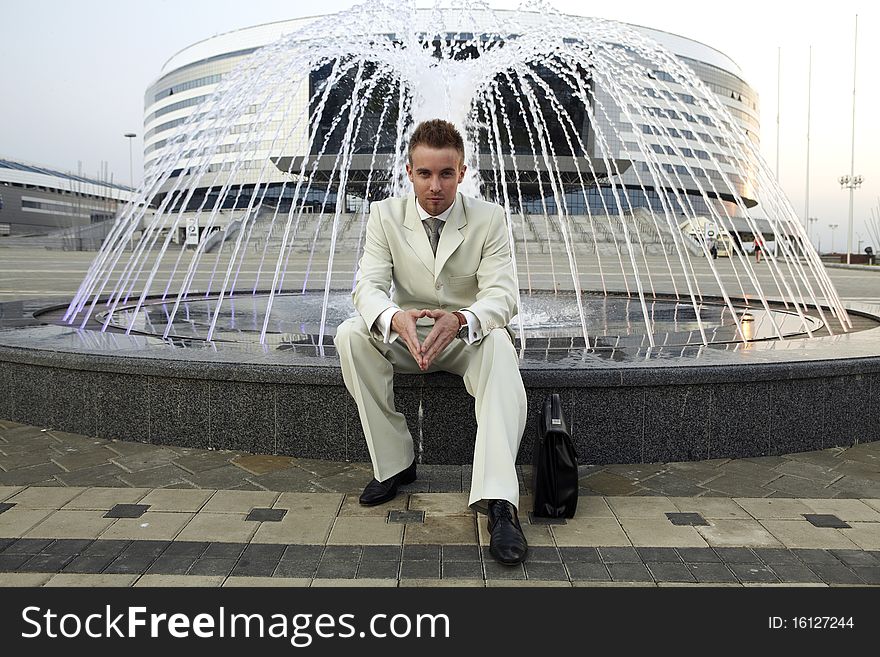 Businessman at fountain on the street.