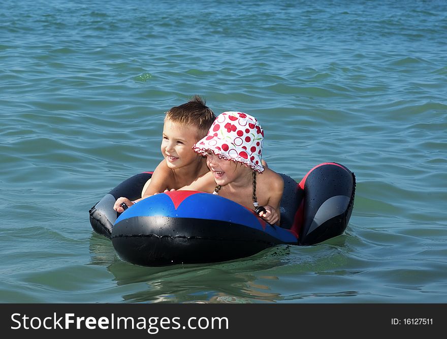 Happiness little boy and girl swimming on sea mattress together. Happiness little boy and girl swimming on sea mattress together