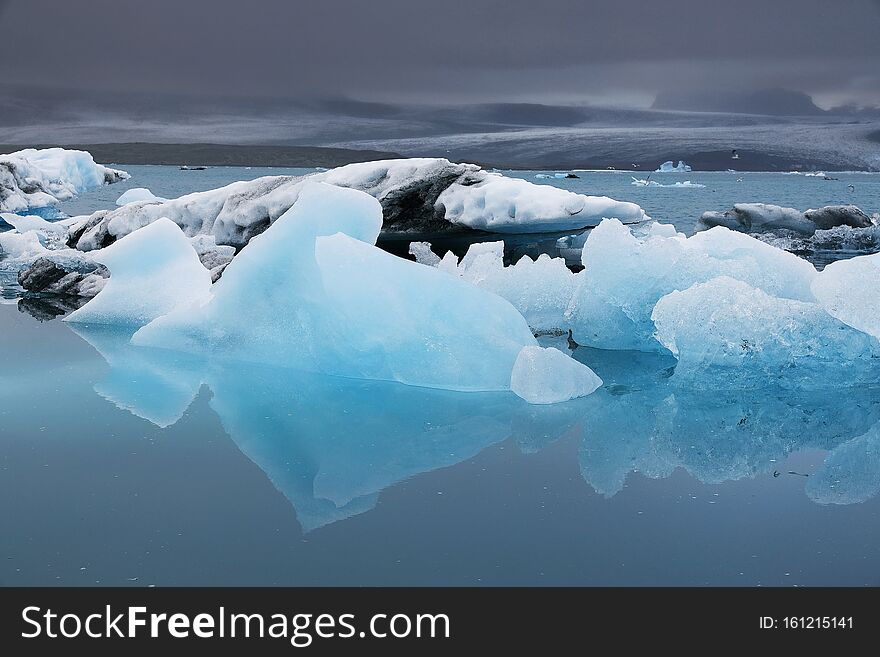 Jokulsarlon is a lake that is filled with the meltwater from the Breidamerkurjokull, a tongue of Europeâ€™s largest ice cap, Vatnajokull. It stands out, however, due to the fact that it also fills with icebergs breaking from the glacier, some of which tower several stories high. These icebergs, other than their scale, are notable for their colouration. Although they are, as expected, largely white, most are also dyed electric blue in part, with black streaks of ash from eruptions centuries past. When the icebergs finally make it across the lagoon, they either drift out to sea or wash up on the nearby shore. Because of the way they glisten against the black sands of Breidamerkursandur, this area has been nicknamed â€˜the Diamond Beachâ€™. Iceland, Europe. Jokulsarlon is a lake that is filled with the meltwater from the Breidamerkurjokull, a tongue of Europeâ€™s largest ice cap, Vatnajokull. It stands out, however, due to the fact that it also fills with icebergs breaking from the glacier, some of which tower several stories high. These icebergs, other than their scale, are notable for their colouration. Although they are, as expected, largely white, most are also dyed electric blue in part, with black streaks of ash from eruptions centuries past. When the icebergs finally make it across the lagoon, they either drift out to sea or wash up on the nearby shore. Because of the way they glisten against the black sands of Breidamerkursandur, this area has been nicknamed â€˜the Diamond Beachâ€™. Iceland, Europe