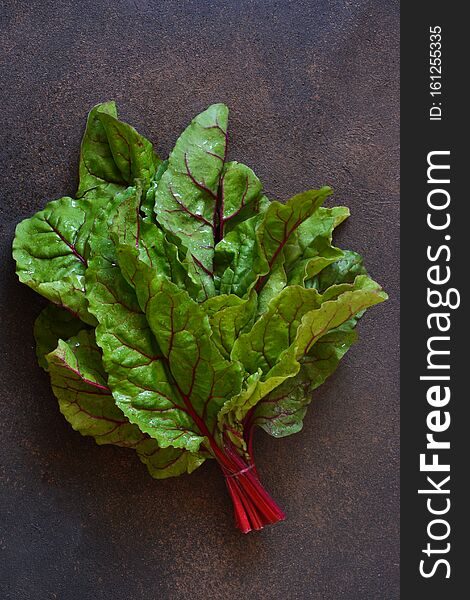 Fresh, raw leaves of the beetroot on a concrete background. Food background