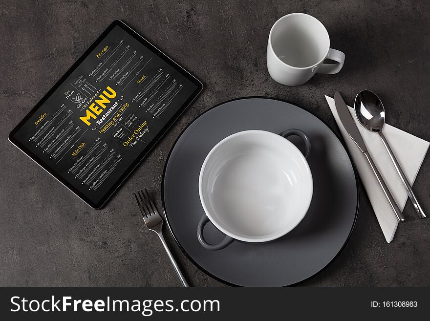 Tableware with online menu on tablet