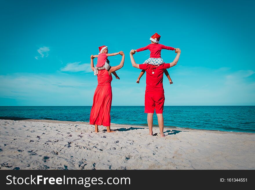 Happy family-mom, dad and kids- on tropical Christmas vacation