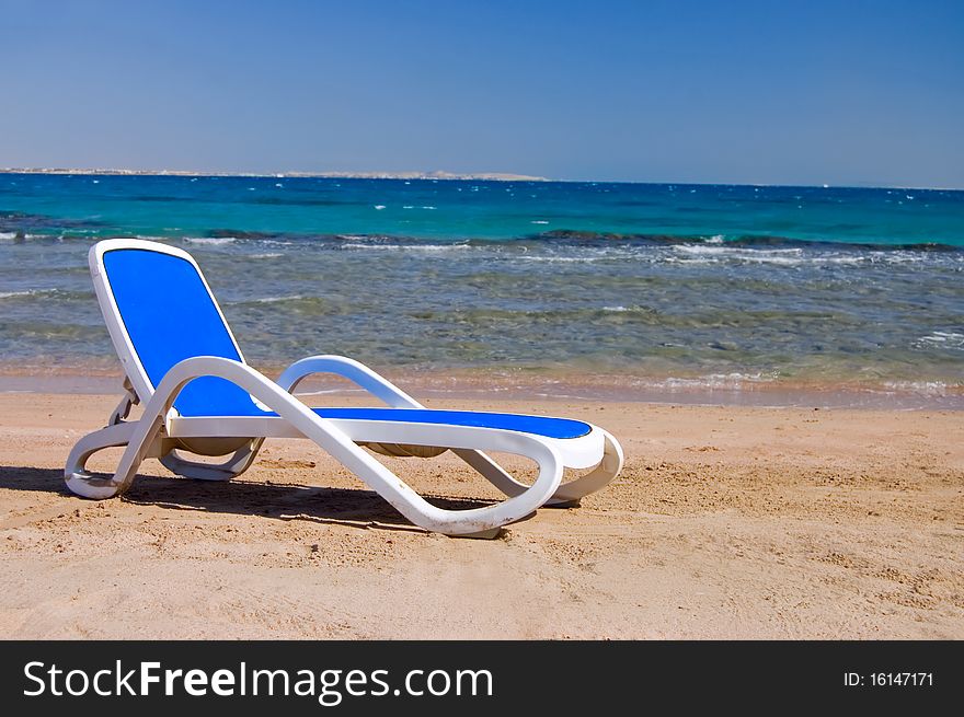 Blue chaise lounge at the sea