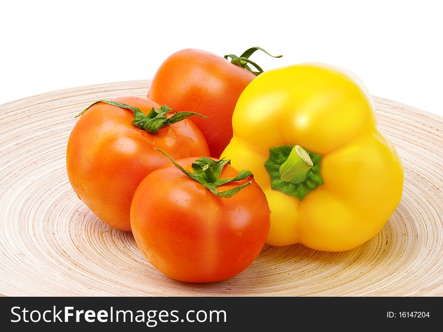 Tomatoes and pepper on wooden plate. Tomatoes and pepper on wooden plate