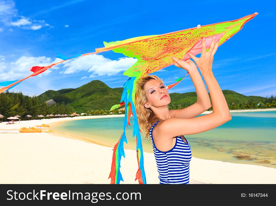 Young woman with kite on the beach