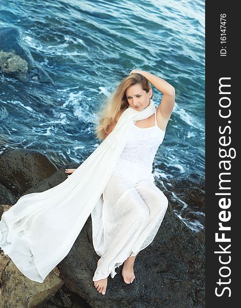 Young beautiful woman posing near the ocean. Young beautiful woman posing near the ocean