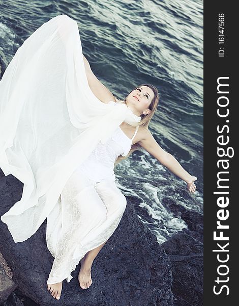 Young beautiful woman posing near the ocean. Young beautiful woman posing near the ocean