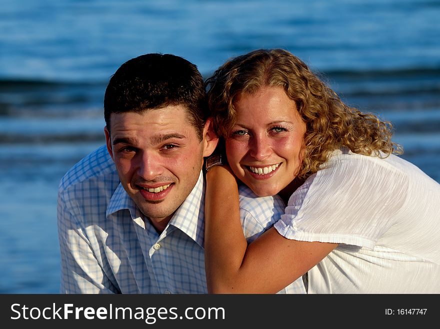 Happy couple is smiling. Taken on beach.